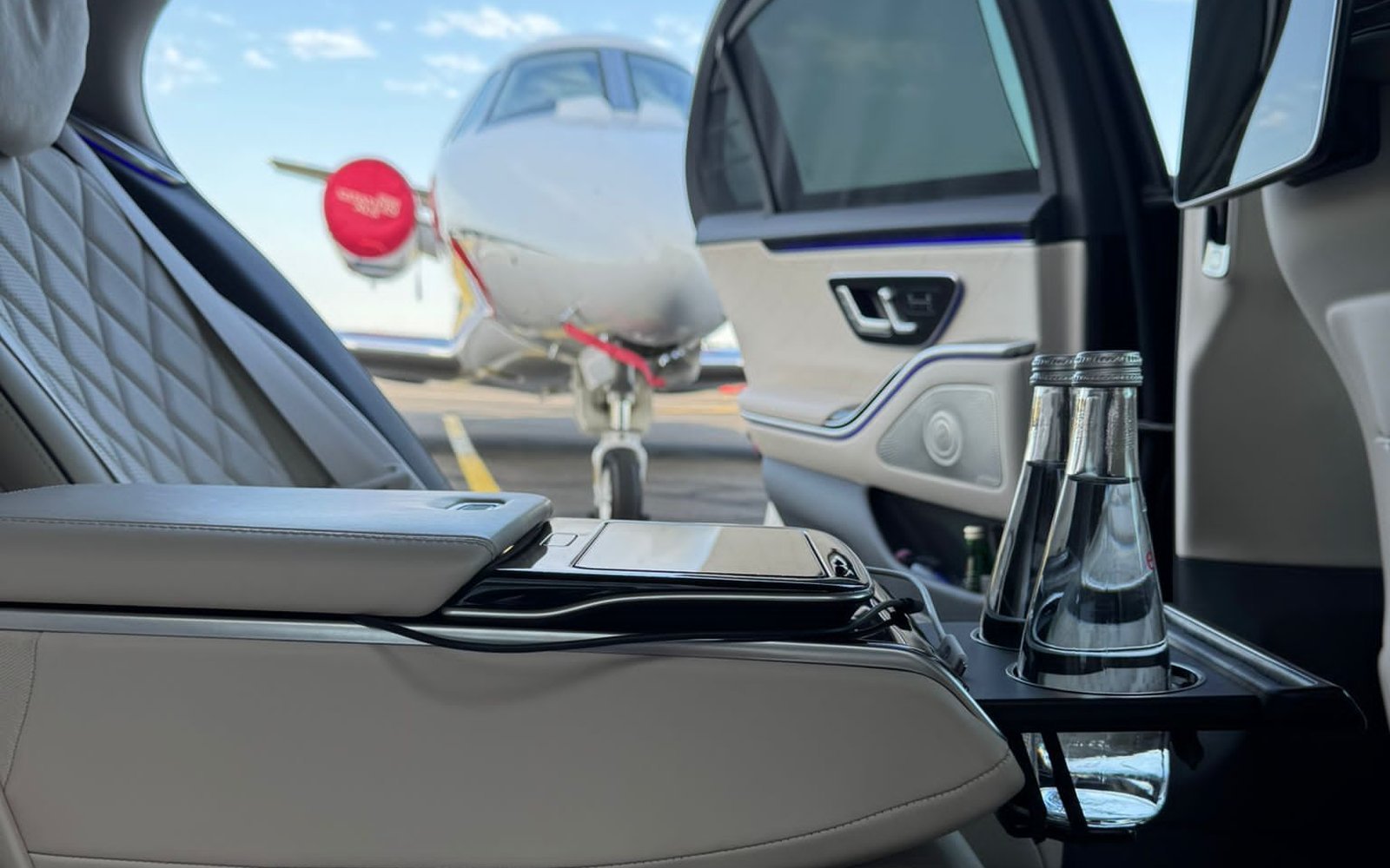 Cabine arrière en cuir d’une Mercedes Classe S, face à un jet privé